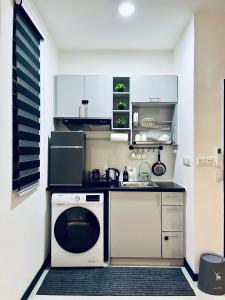 uma pequena cozinha com um lavatório e uma máquina de lavar louça em NEU Suites Cozy Minimalist#KLCC#2BR#Relax#Netflix em Kuala Lumpur