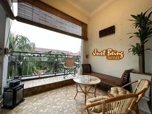 een woonkamer met een balkon met een tafel en stoelen bij Just Being Home 10pax 3BR/3BA 4Queen/1Sofa in Ampang