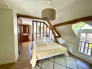 ein Schlafzimmer mit einem Bett und einem großen Fenster in der Unterkunft Propriété en Sologne avec étangs in Villemurlin