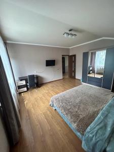 a bedroom with a bed and a flat screen tv at Комнаты у Айрин in Vanadzor