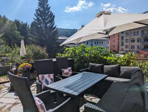 een tafel en stoelen en een parasol op een patio bij Urlaubsmagie - Garten, Whirlpool, Sauna - UO2 in Sebnitz