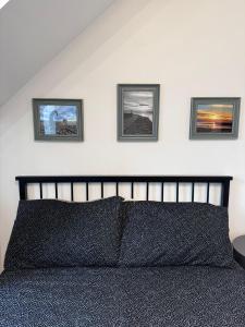 a bedroom with a bed with three pictures on the wall at Parade School Guest Rooms in Berwick-Upon-Tweed