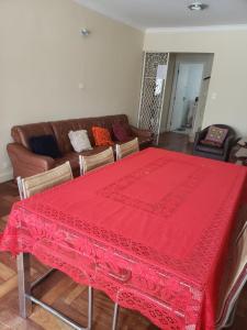 a living room with a red table and a couch at Metro pra da árvore in São Paulo