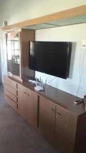 un gran centro de entretenimiento con una gran TV de pantalla plana en Cabaña casa grande en San Antonio de Areco