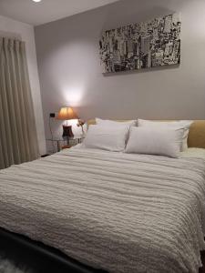 - une chambre avec un grand lit et des draps blancs dans l'établissement Grand​ Diamond Suite Condominium, à Bangkok