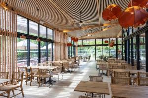 un restaurant vide avec des tables, des chaises et des fenêtres dans l'établissement CityKamp Paris, à Paris