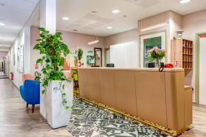 a reception desk in a hospital lobby with plants at Résidence de Maisons-Laffitte in Maisons-Laffitte