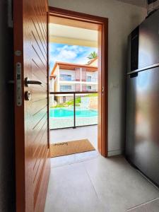 a door to a balcony with a view of a pool at Summer Charme in Morro de São Paulo