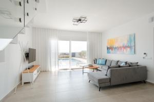 a living room with a couch and a tv at Villa Marina Hills in Makry Gialos