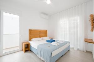 a white bedroom with a bed and a large window at Villa Marina Hills in Makry Gialos +35 photos