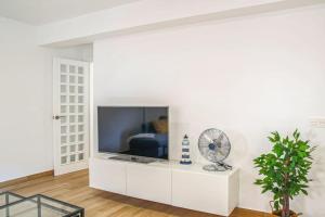 a white living room with a tv on a white wall at Magnífico apto. pleno centro Almeria in Almería
