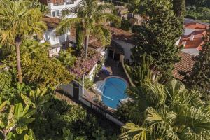 an overhead view of a building with a swimming pool and palm trees at Quinta Florença - By WeHost in Funchal
