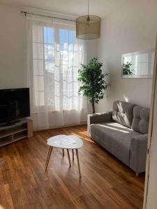 un soggiorno con divano e tavolo di Appartement Notre Dame 2 a Montluçon