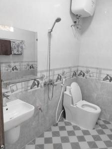 uma casa de banho com um chuveiro, um WC e um lavatório. em Đồi Thông Homestay em Làng Me