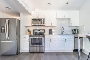 a kitchen with white cabinets and stainless steel appliances at Cute as a Button! in Seattle