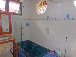 a bathroom with a tub and a sink at Hotel Cantinho de Férias in Visconde De Maua