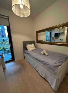 a bedroom with a bed with a mirror on the wall at Shared Modern apartment with pets by the waterfront in Stockholm