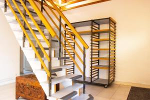 un escalier en colimaçon dans une maison avec des balustrades jaunes dans l'établissement Le gîte campagnard à 10 min de Poitiers, à Migné-Auxances