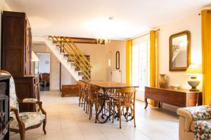 a dining room with a table and chairs and a staircase at Le gîte campagnard à 10 min de Poitiers in Migné-Auxances