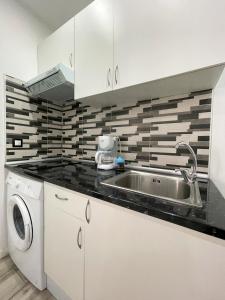 a kitchen with a sink and a washing machine at Apartments near metro in Madrid
