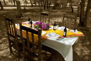 a table with a yellow table cloth and wine bottles at NSYA CAMP MANYARA in Mto wa Mbu