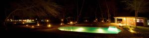 a pool with lights in a yard at night at NSYA CAMP MANYARA in Mto wa Mbu