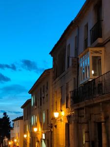 an old building with lights on a street at night at Casa de las Lías in Chinchón