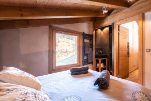 a bedroom with a large bed and a window at Chalet Alpen in Praz-sur-Arly