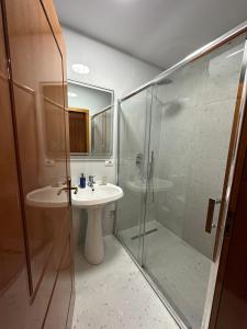 a bathroom with a glass shower and a sink at Cozy Apartment, in the center of Tirana in Tirana