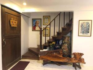 uma sala de estar com uma escada com um homem numa fotografia em Heart of Paete Laguna, Camarero Transient House em Paete
