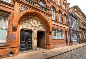 a brick building with an archway on a city street at Mezz Apartment Four in Hull