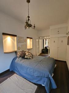 哥多華的住宿－Martinolli5130，一间卧室配有一张带蓝色床单和吊灯的大床