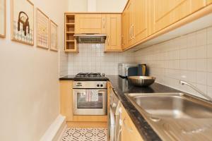 a kitchen with a sink and a stove at The Crystal Palace Crib - Lovely 1BDR Flat in Crystal Palace