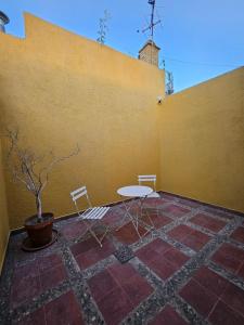 un patio con mesa y sillas junto a una pared en Martinolli5130 en Córdoba