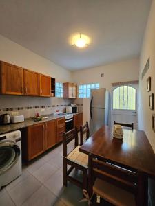 a kitchen with a table and a refrigerator at Martinolli5130 in Córdoba