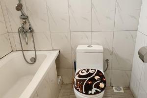 a bathroom with a toilet with a design on it at Sanz Cozy Stay; Butenga Estate, Kira. in Kira