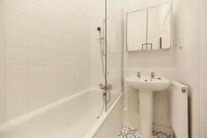 a white bathroom with a sink and a bath tub at The Crystal Palace Crib - Lovely 1BDR Flat in Crystal Palace