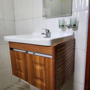 ein Bad mit einem Waschbecken und einem Spiegel in der Unterkunft Sanz Cozy Stay; Butenga Estate, Kira. in Kira