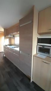 een keuken met een magnetron en een fornuis top oven bij RBR 1252 - Beach Resort Kamperland in Kamperland