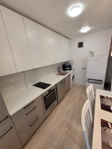 a kitchen with white cabinets and a white refrigerator at Апартаменты in Rīga