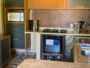 a kitchen with a stove and a microwave at La Maison Cocobanana in Itacaré