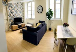 a living room with a couch and a table and a clock at Appartement standing pour 4 in Toulon