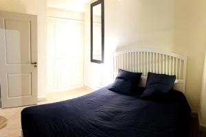 - une chambre dotée d'un lit avec des draps bleus et un miroir dans l'établissement Appartement standing pour 4, à Toulon