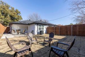 a backyard with chairs and a table and a fence at Lux Modern Getaway with ATT Stadium Views and King Bed in Arlington