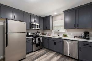 a kitchen with black cabinets and stainless steel appliances at Lux Modern Getaway with ATT Stadium Views and King Bed in Arlington