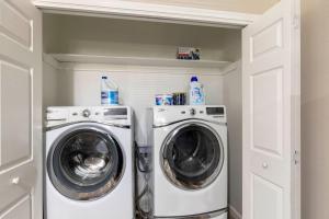 a laundry room with a washer and dryer at Lux Modern Getaway with ATT Stadium Views and King Bed in Arlington