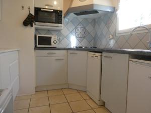 - une petite cuisine avec des placards blancs et un four micro-ondes dans l'établissement Gite La Balaguere, à Cauterets