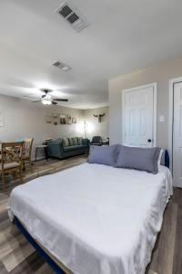 a bedroom with a large white bed and a living room at Family and Dog Friendly Retreat in Arlington