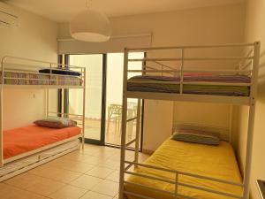 two bunk beds in a room with a window at Casa das Pedras Pretas in Porto Santo