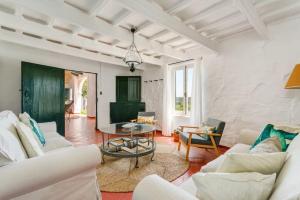 a living room with white furniture and a table at Finca BellaMirada in Es Mercadal